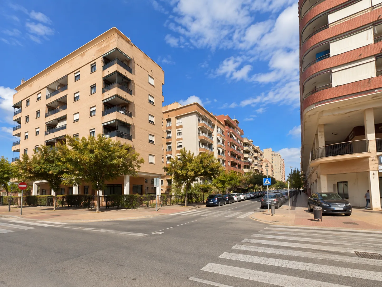 Calle residencial de Colonia Madrid en Benidorm con edificios de viviendas y cruce peatonal